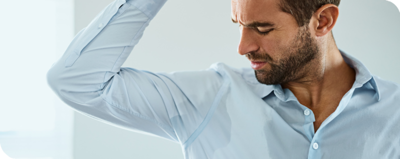 Mann mit Hyperhidrose leidet unter Schweißflecken auf dem Hemd